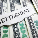 cash and a paper labelled settlement for personal injury settlements cash and a paper labelled settlement for personal injury settlements